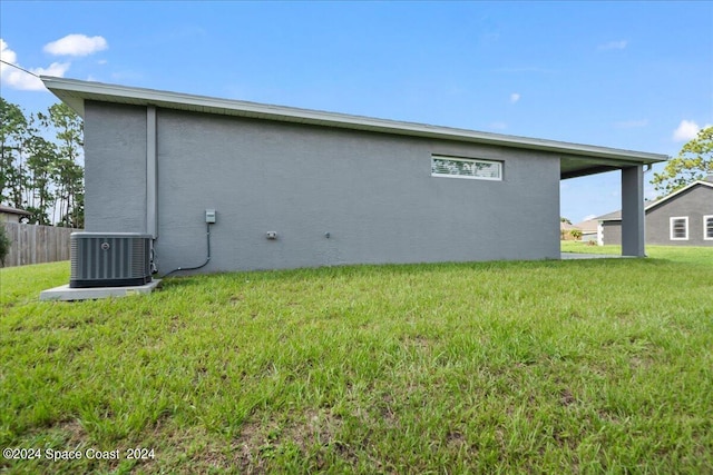 view of home's exterior with cooling unit and a yard