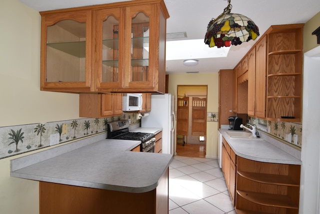 kitchen with pendant lighting, white appliances, sink, light tile patterned floors, and kitchen peninsula