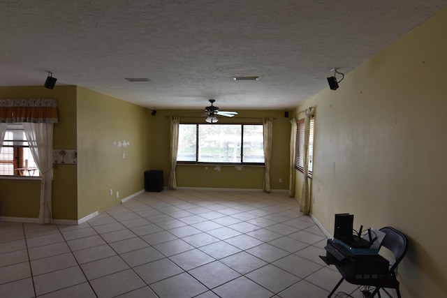 unfurnished room featuring a textured ceiling, ceiling fan, and light tile patterned flooring