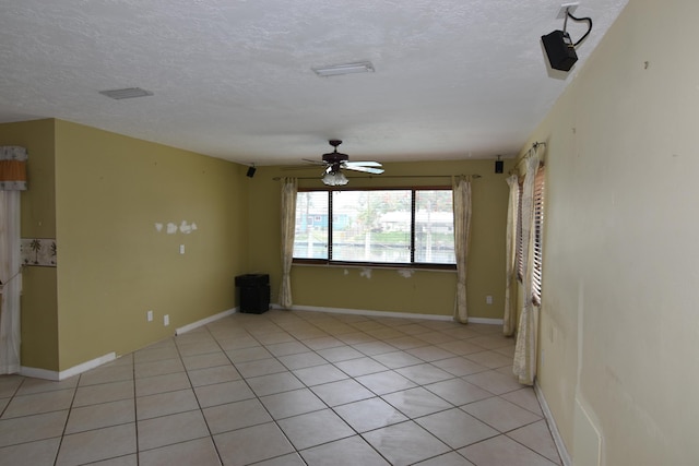 spare room featuring light tile patterned floors, a textured ceiling, and ceiling fan