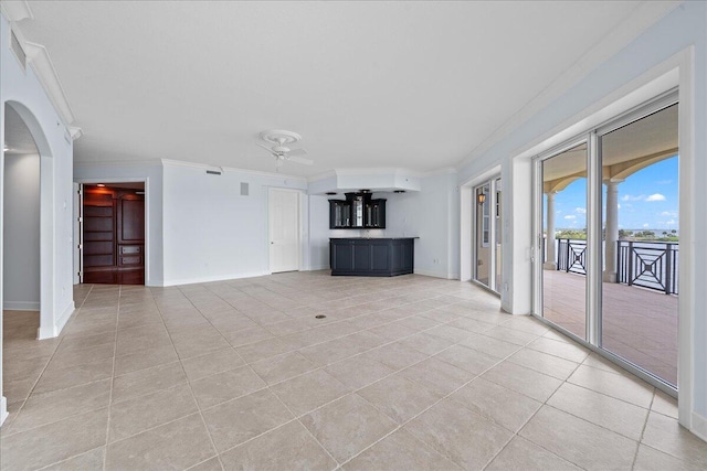 unfurnished living room featuring ceiling fan, light tile patterned flooring, and ornamental molding