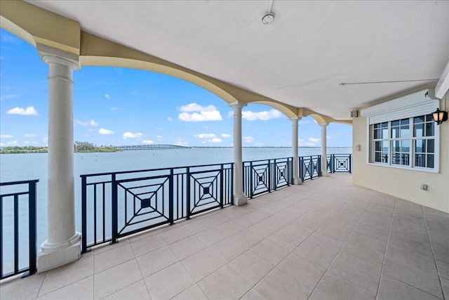 view of patio featuring a balcony and a water view