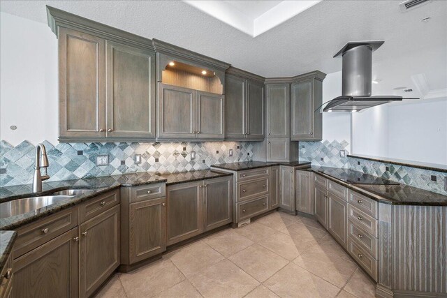 kitchen with tasteful backsplash, island exhaust hood, and dark stone counters