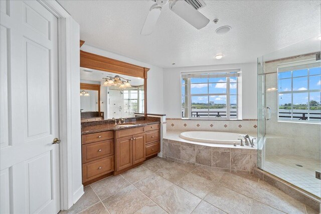 bathroom featuring separate shower and tub, ceiling fan, a textured ceiling, and vanity