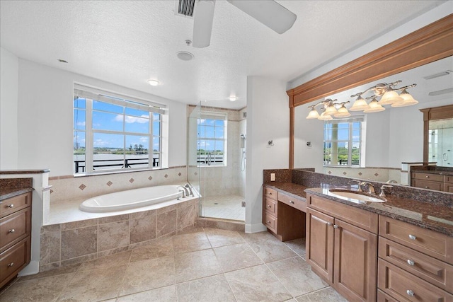 bathroom with vanity, a textured ceiling, ceiling fan, and shower with separate bathtub