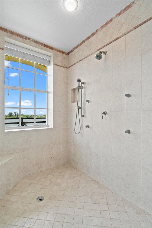 bathroom featuring tiled shower and a textured ceiling