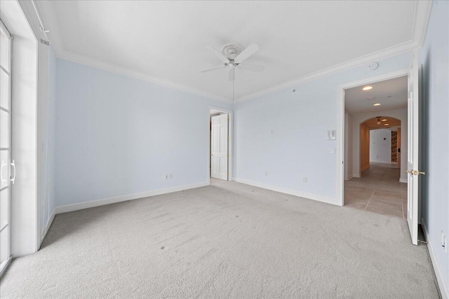 carpeted spare room with ceiling fan and crown molding