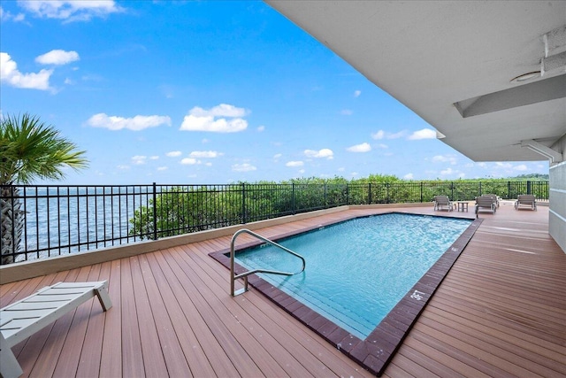 view of pool with a patio area, fence, a fenced in pool, and a water view