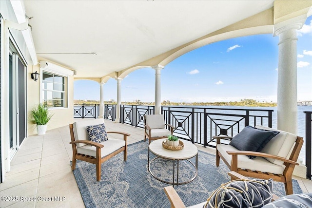 view of patio / terrace with a water view, outdoor lounge area, and a balcony