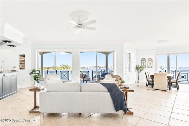 living area featuring crown molding, light tile patterned flooring, and a healthy amount of sunlight