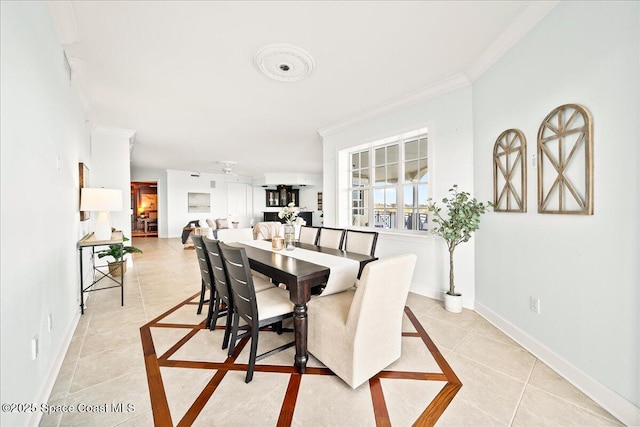 dining room with ornamental molding, light tile patterned flooring, and baseboards