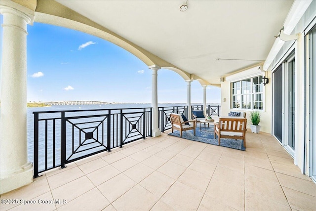 view of patio with a water view and a balcony