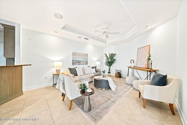 living room with baseboards, a raised ceiling, ceiling fan, ornamental molding, and light tile patterned flooring