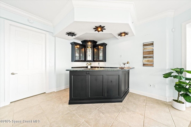 bar with light tile patterned floors, crown molding, baseboards, and indoor wet bar