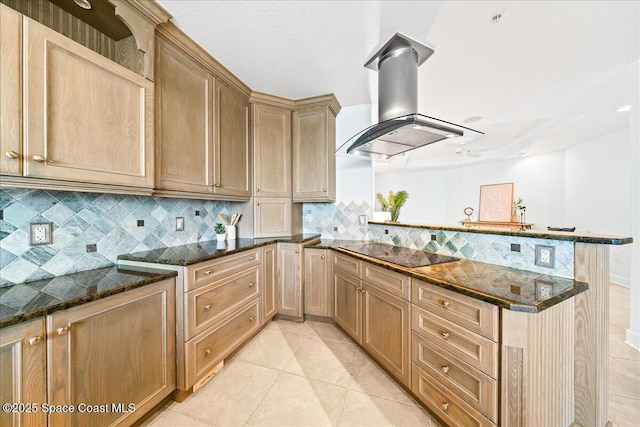 kitchen with light tile patterned flooring, island range hood, dark stone counters, a peninsula, and black electric cooktop