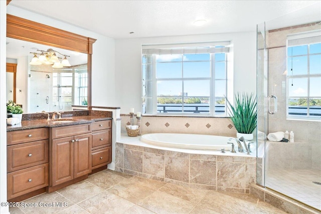 bathroom with a stall shower, a healthy amount of sunlight, and vanity