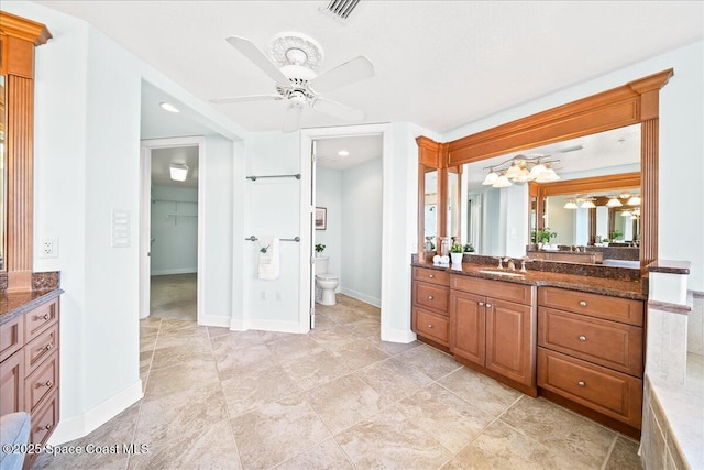 bathroom featuring baseboards, visible vents, vanity, and toilet