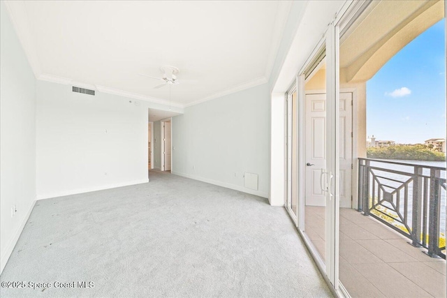 empty room featuring ornamental molding, light colored carpet, visible vents, and ceiling fan