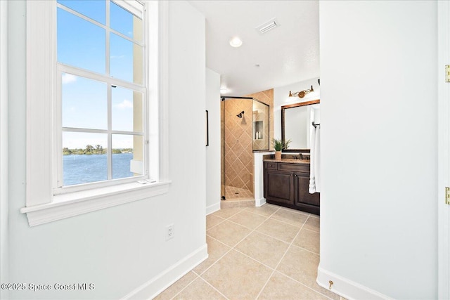 full bathroom featuring a water view, visible vents, vanity, a shower stall, and tile patterned floors