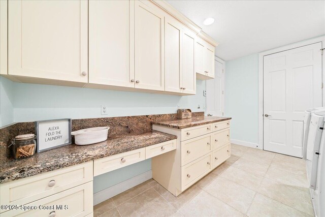 kitchen featuring dark stone counters, light tile patterned floors, cream cabinets, and baseboards