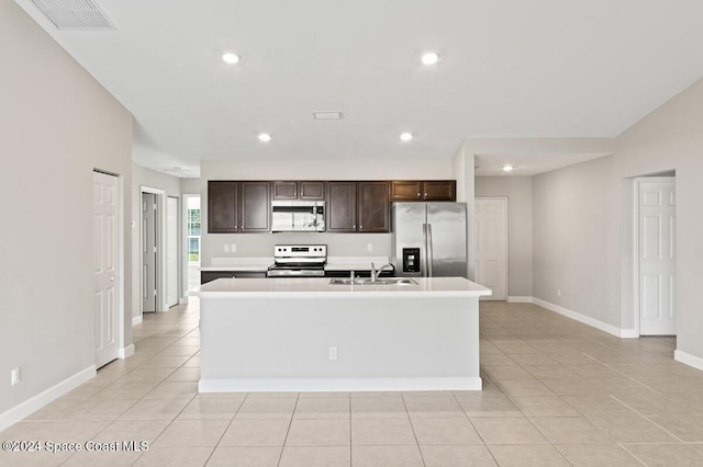 kitchen featuring sink, stainless steel appliances, a center island with sink, and light tile patterned floors