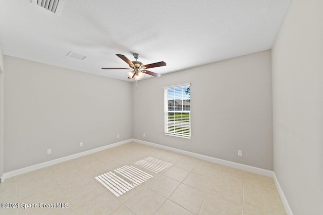 tiled spare room featuring a textured ceiling and ceiling fan