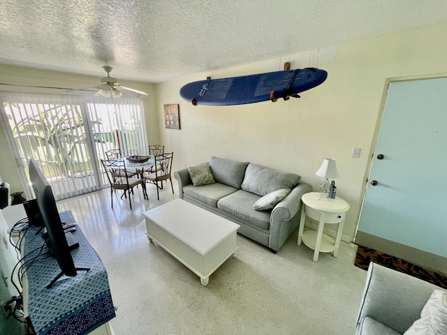 living room featuring a textured ceiling and ceiling fan