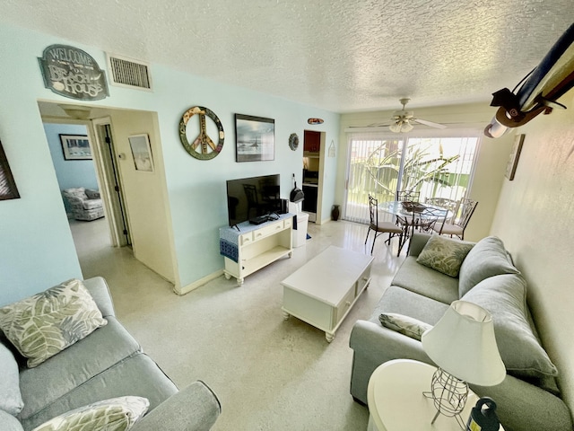 living room featuring a textured ceiling and ceiling fan