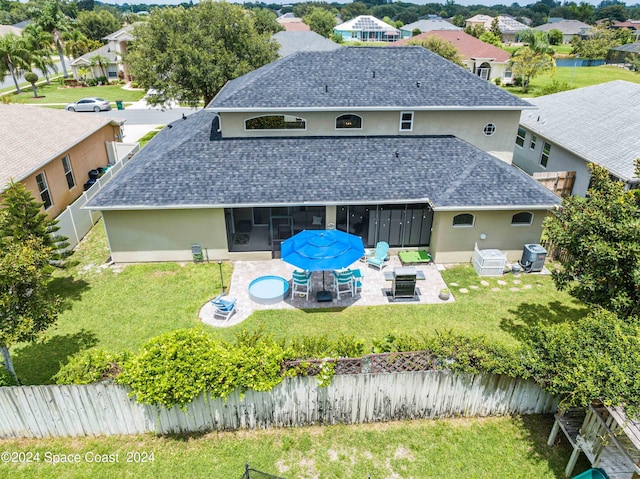 rear view of house with a yard, a patio, an outdoor fire pit, central AC unit, and a sunroom