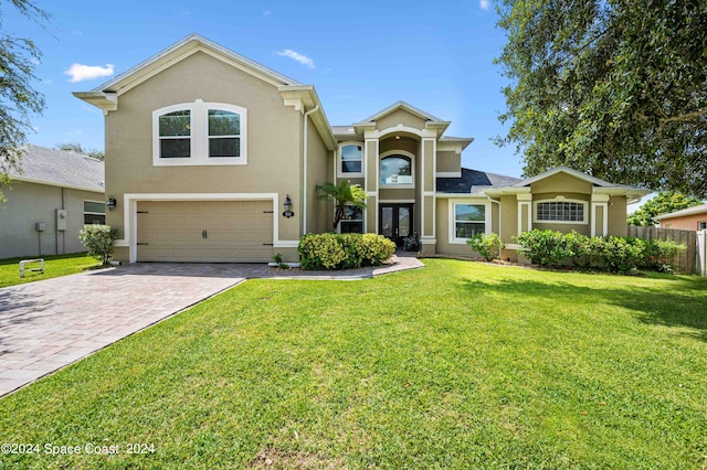 view of property with a garage and a front lawn