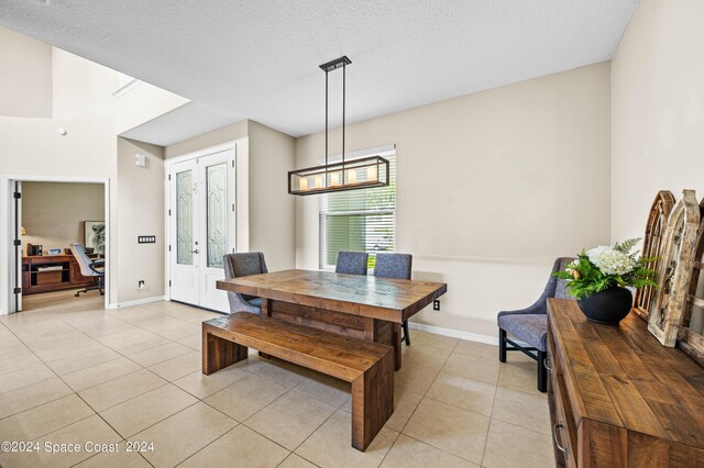 dining space featuring a textured ceiling and light tile patterned floors