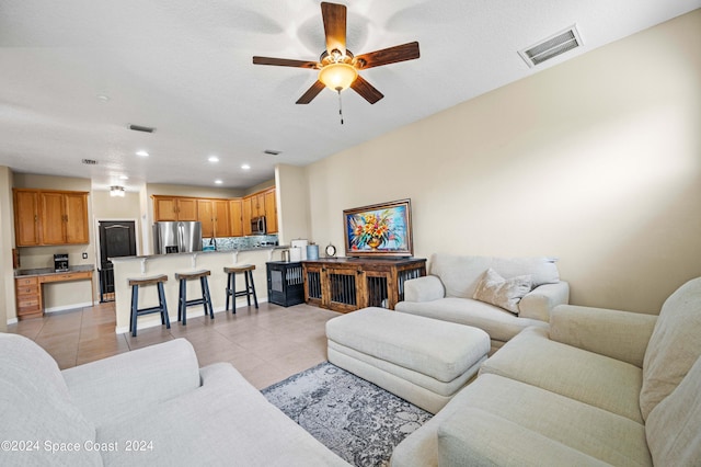 living room featuring light tile patterned floors and ceiling fan