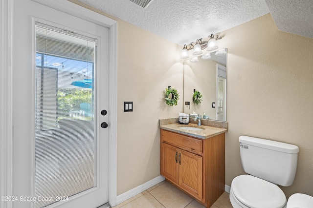 bathroom with tile patterned floors, toilet, a textured ceiling, and vanity