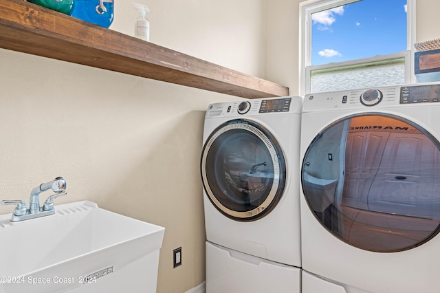 clothes washing area featuring sink and washing machine and dryer