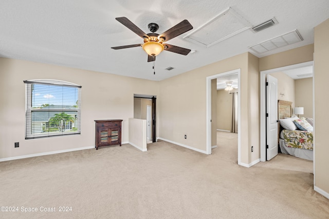 unfurnished living room with ceiling fan, a textured ceiling, and light carpet