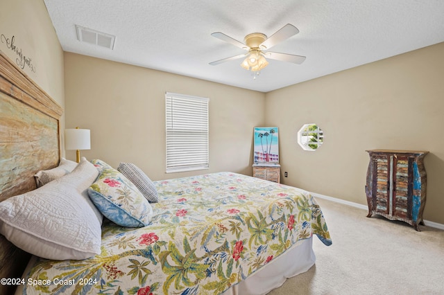 carpeted bedroom featuring multiple windows, ceiling fan, and a textured ceiling