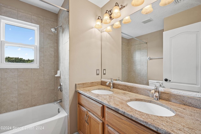 bathroom featuring tiled shower / bath and vanity