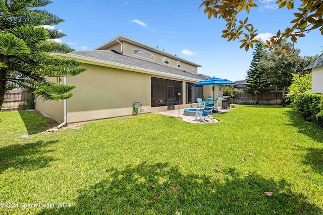 back of property with a patio, a sunroom, and a lawn