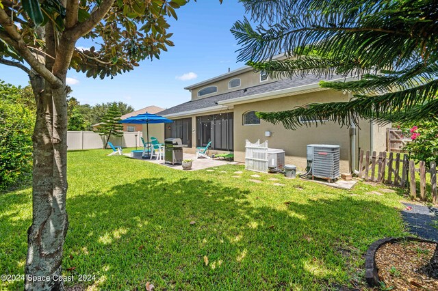 exterior space with cooling unit, a patio area, and a yard