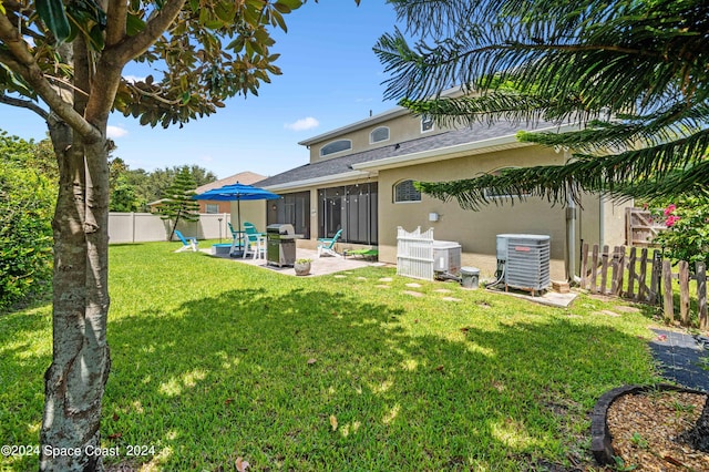 back of property featuring a lawn, a patio area, and central air condition unit