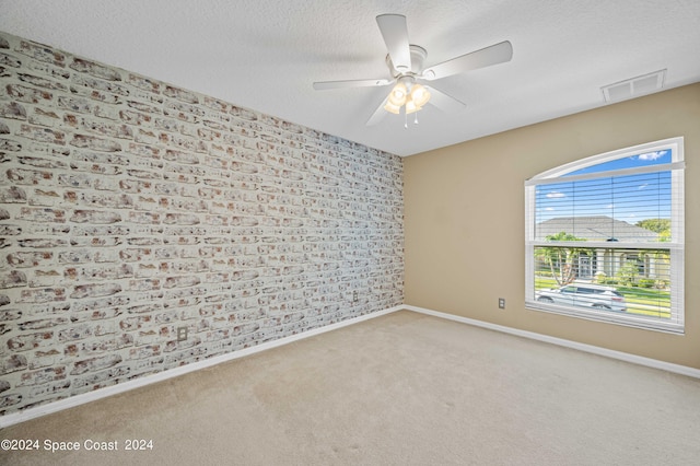 carpeted empty room with ceiling fan and a textured ceiling