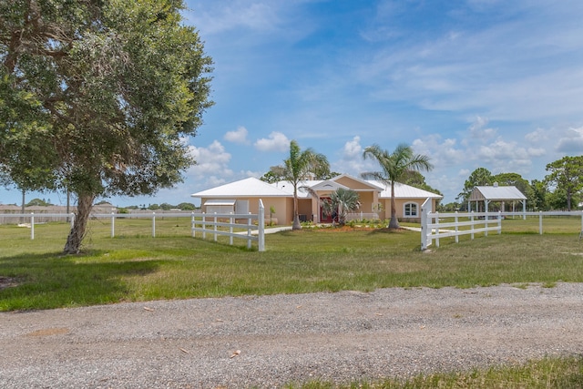 view of front of property featuring a rural view, a gazebo, and a front lawn