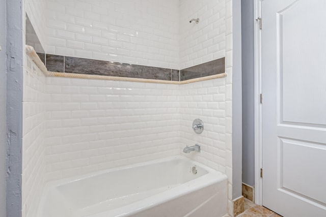 bathroom with tiled shower / bath combo and tile patterned flooring