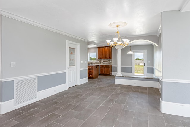 interior space featuring decorative columns, sink, crown molding, tile patterned floors, and a chandelier