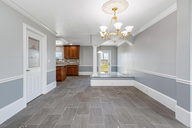 kitchen featuring tasteful backsplash, an inviting chandelier, ornate columns, pendant lighting, and ornamental molding