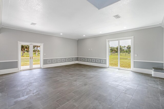 empty room with crown molding, french doors, and a textured ceiling