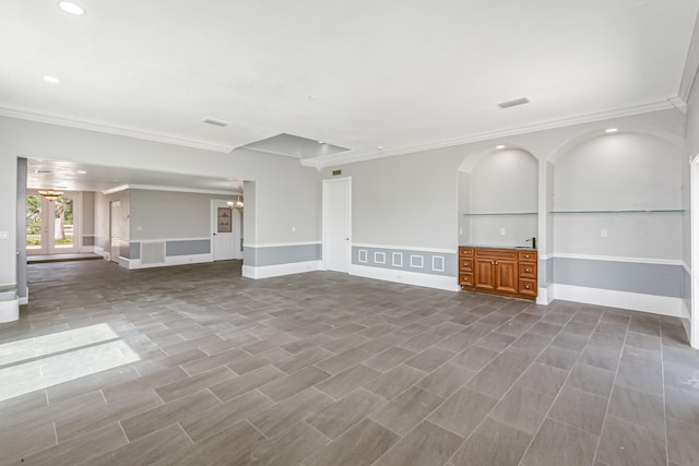 unfurnished living room with ornamental molding and built in features