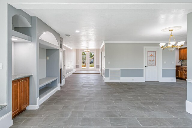 interior space with ornamental molding, sink, tile patterned flooring, and a chandelier