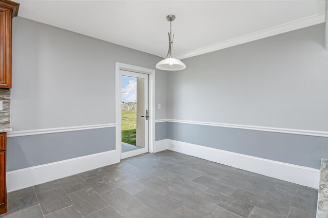 unfurnished dining area featuring dark tile patterned flooring