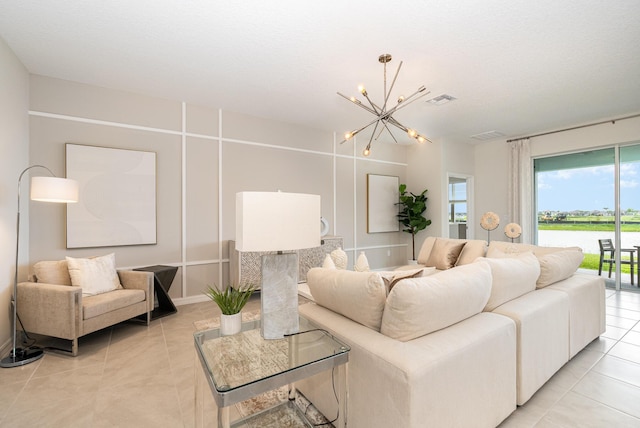 living room with light tile patterned flooring, a water view, and an inviting chandelier